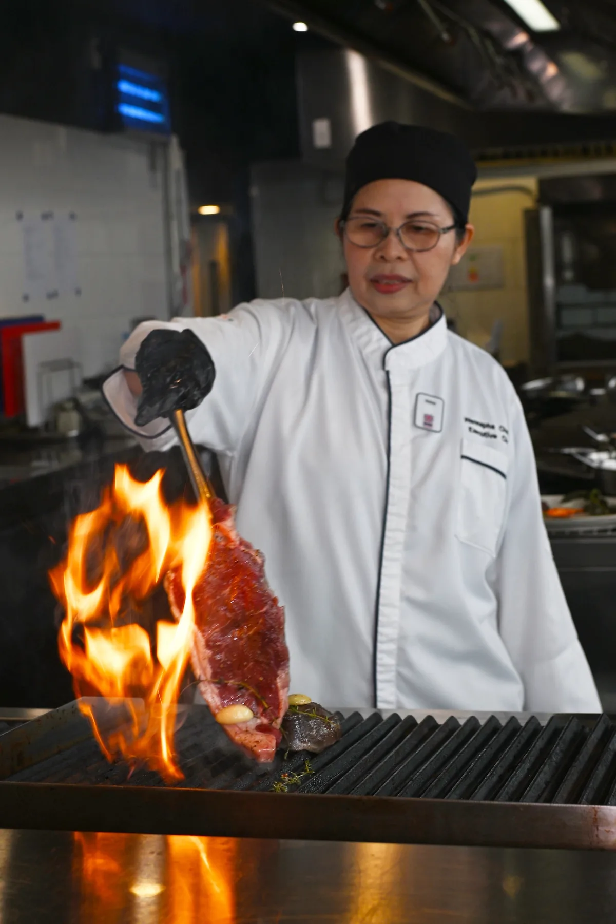 炭火の炎の上でステーキを焼くエグゼクティブシェフ Chef Mam