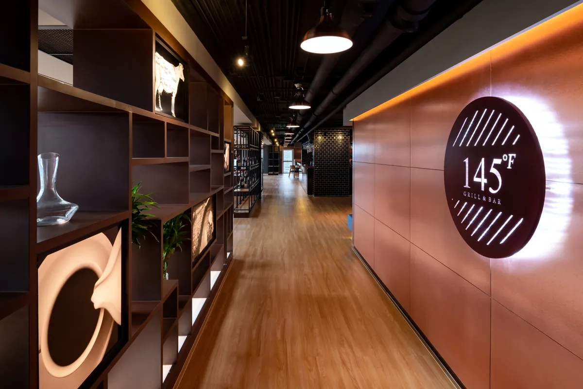 店頭の銅の壁に光る 145°F Grill & Bar のロゴサイン