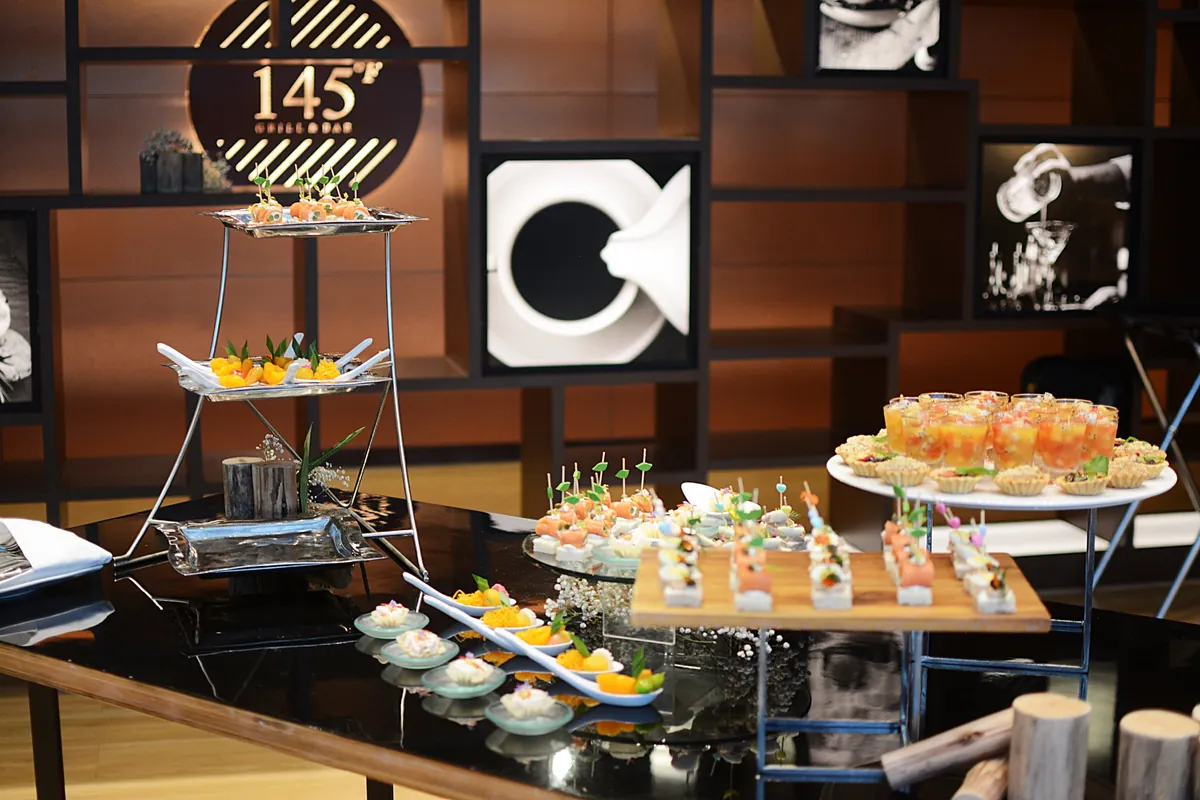 145°F Grill & Bar のロゴウォール前に並ぶ canapé のテーブル