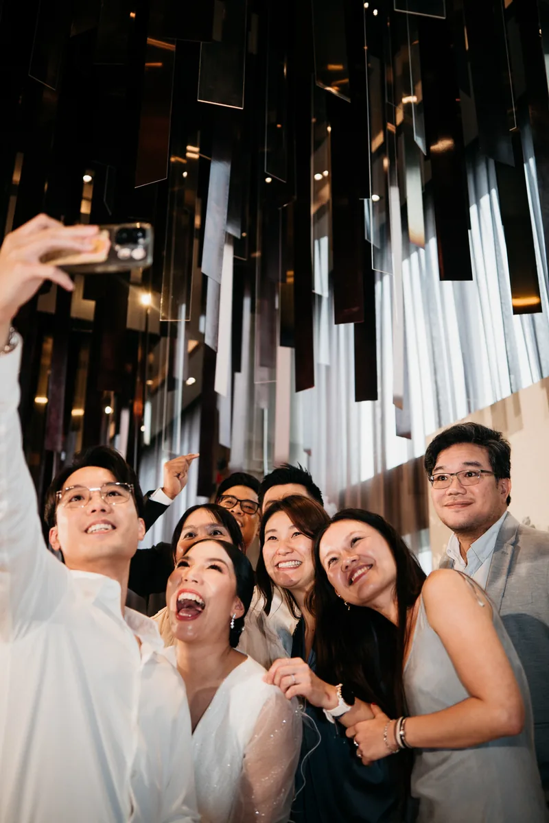 บ่าวสาวถ่าย selfie กับเพื่อนใต้งานทองแดงแขวนเพดาน
